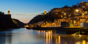 The city of Bristol in the evening, with Clifton Suspension Bridge lit up. 